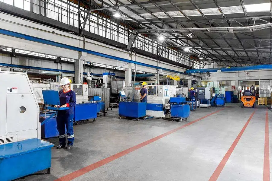 Fertigungshalle mit CNC-Maschinen und Bedienern – serieller Metallbau
