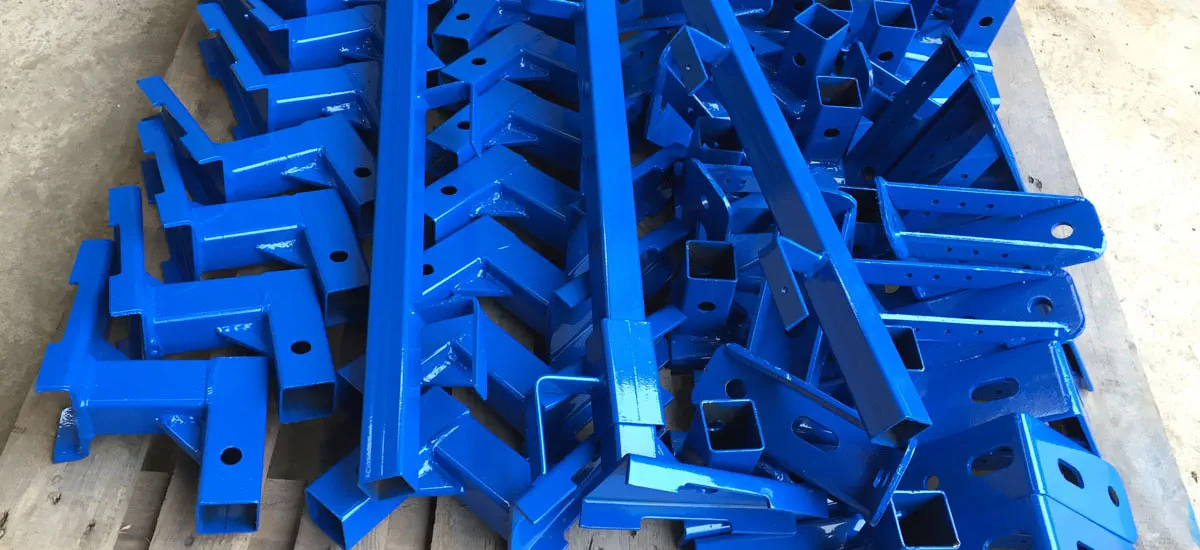 Gelbe Metallteile in Pulverbeschichtungskabine – gleichmäßiger Farbauftrag